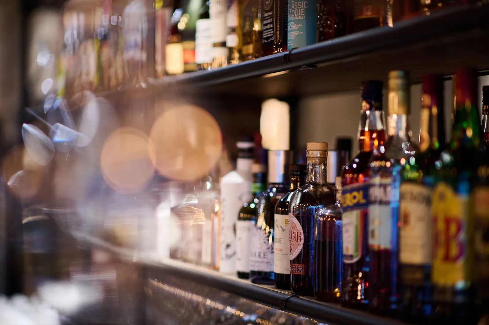 Flessen sterkedrank op een rek achter de bar