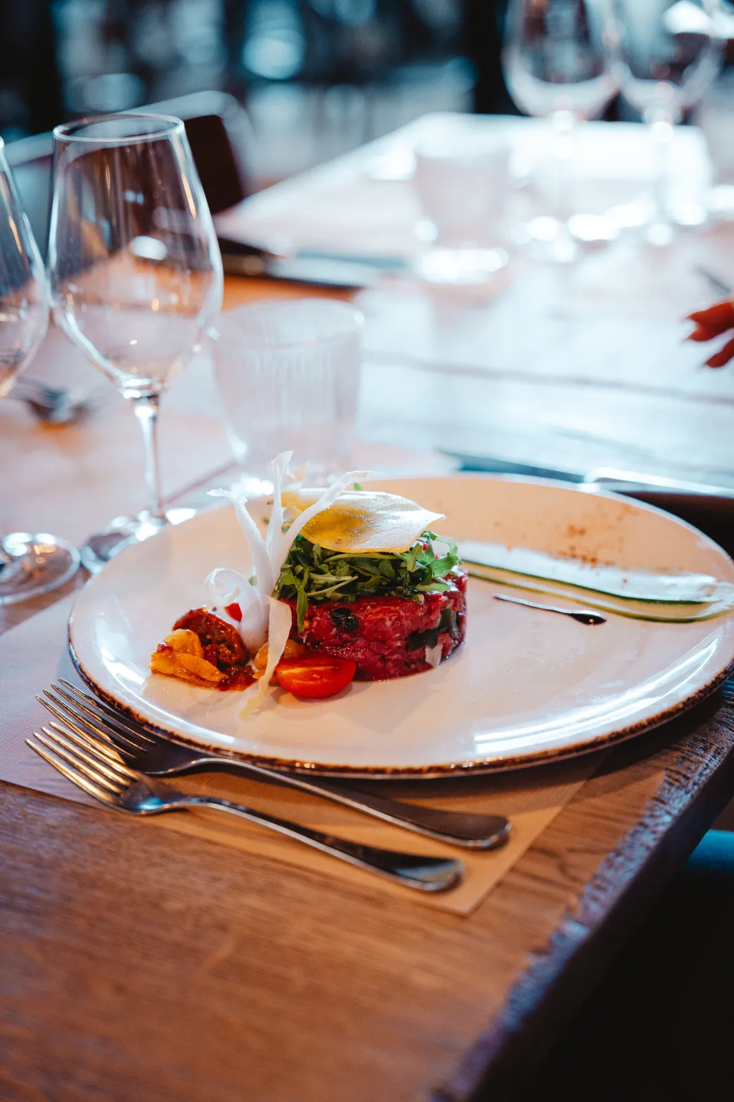 Rundstartaar met rucola, tomaatjes en een eitje op een bord