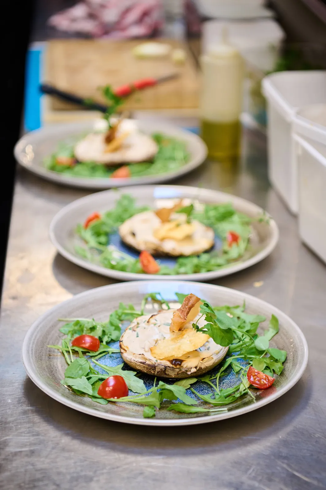 Drie borden rucola met kerstomaatjes en een warm kaastoastje