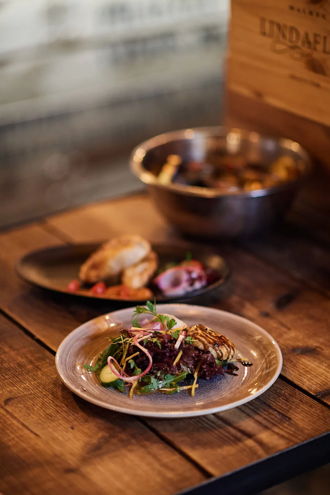 Salade met rode ui en andere gerechten op een houten tafel