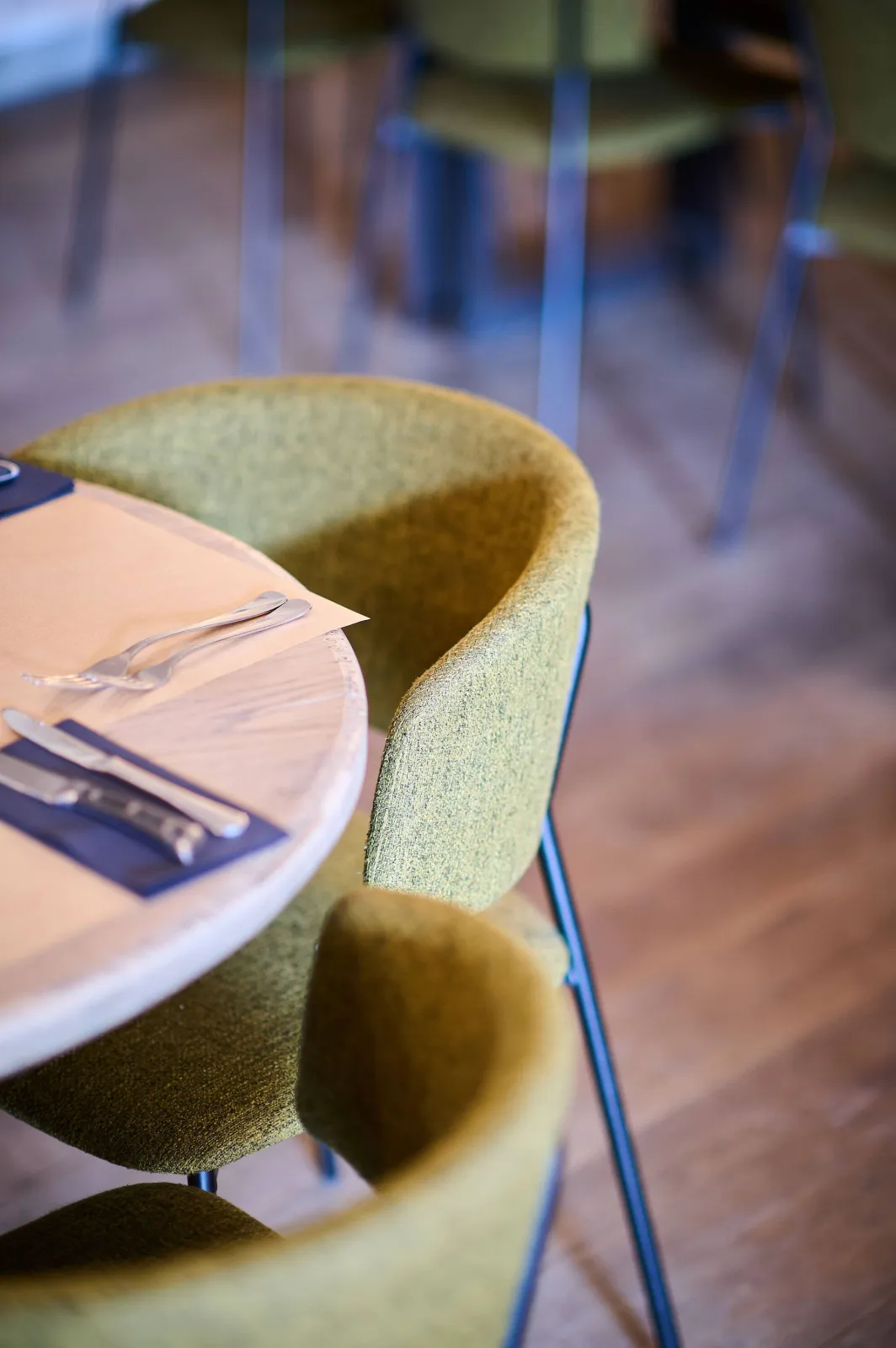 Groene stoelen rond een gedekte houten tafel