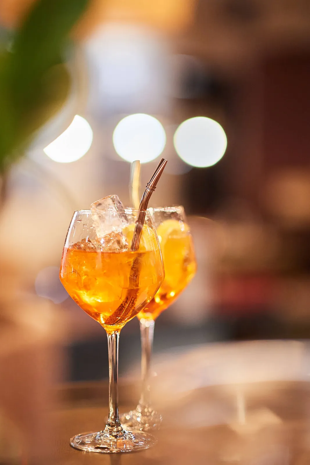 Twee oranje spritzcocktails met ijs in wijnglazen