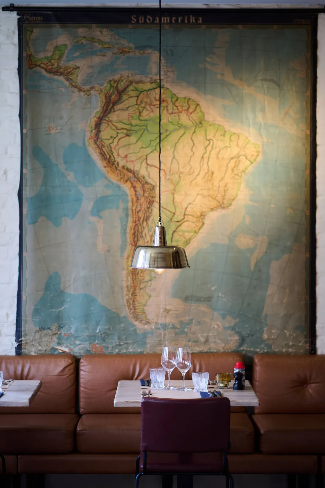 Grote kaart van Zuid-Amerika aan de muur boven een tafel