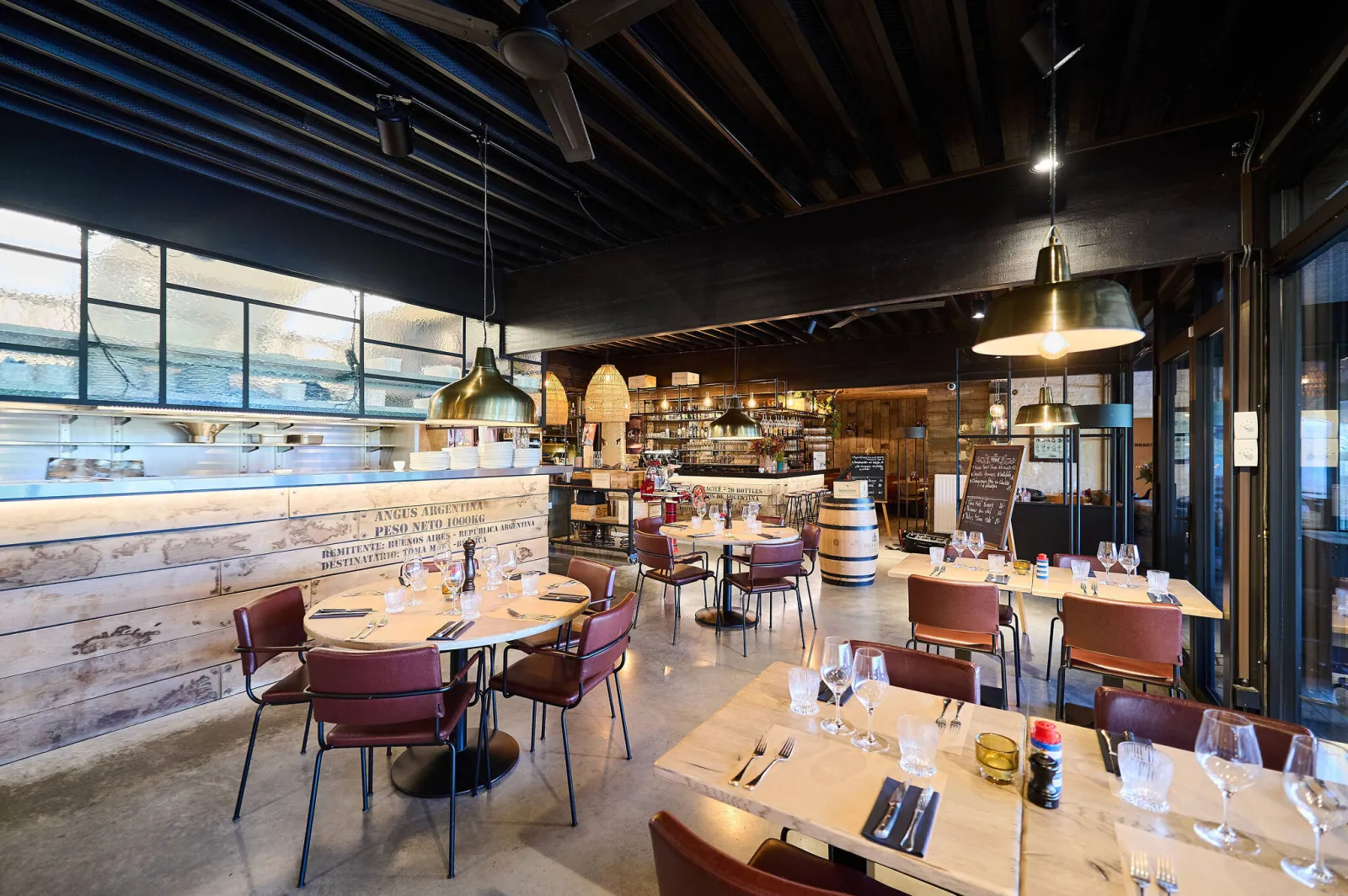 Eetzaal met houten bar, gedekte tafels en koperen hanglampen