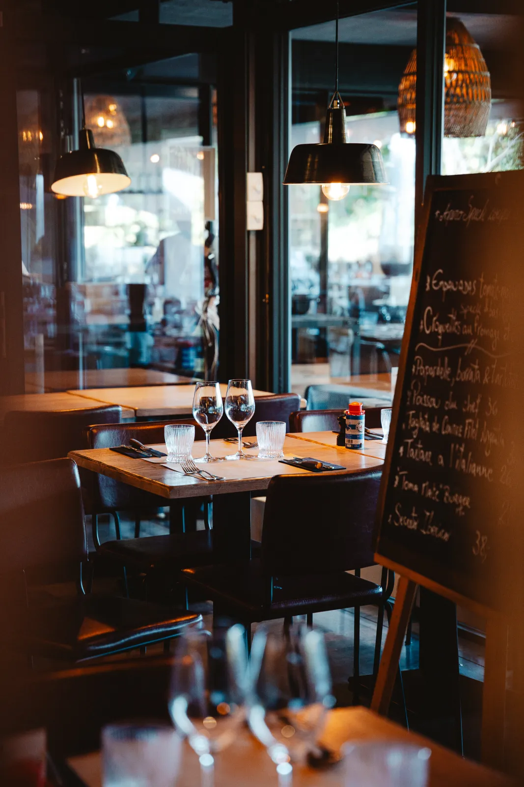 Gedekte tafel bij het raam naast een krijtbord met suggesties
