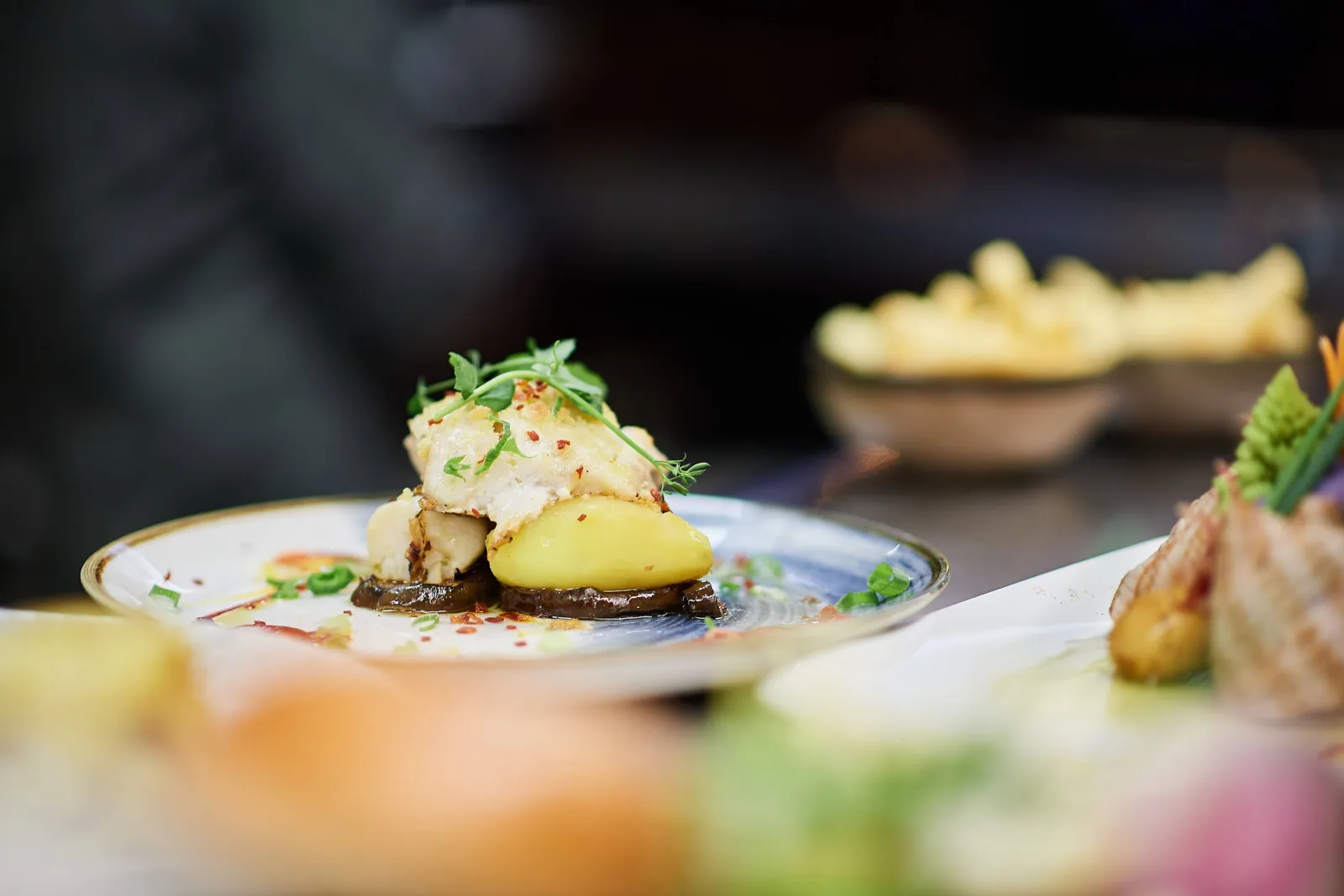Witte vis op aardappel met kruiden, frietjes op de achtergrond