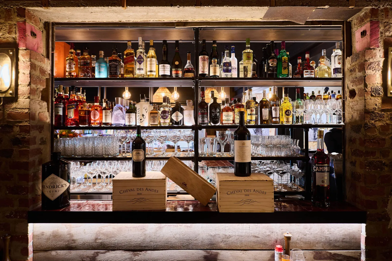 Achterwand van de bar met flessen, glazen en wijnkisten